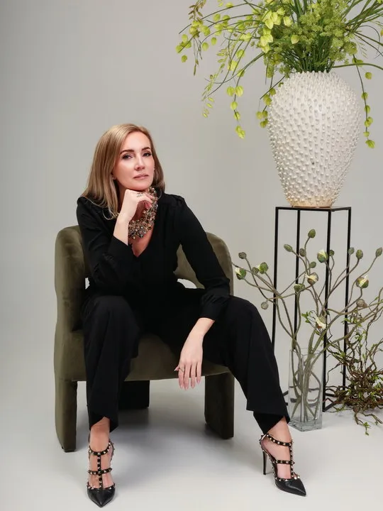 Ásta Björk Sigþórsdóttir, stofnandi Studio Bloom, situr við háa skreytingu